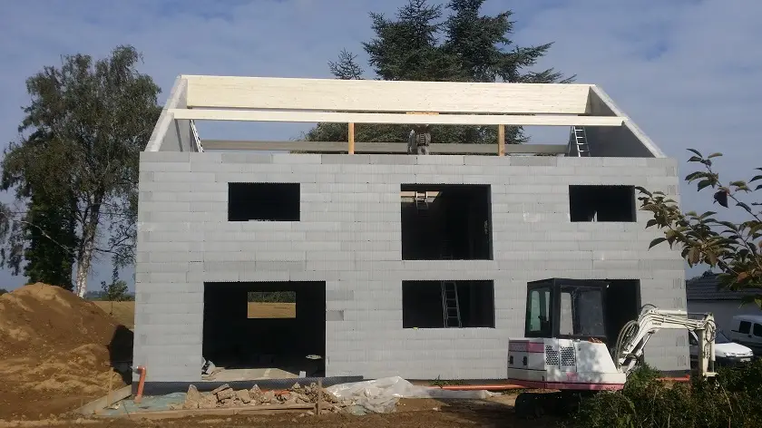 Pose de nos poutres de support pour la toiture en bois "lamellé-collé", un matériau très résistant qui permet la réalisation d'une structure de grande dimension.