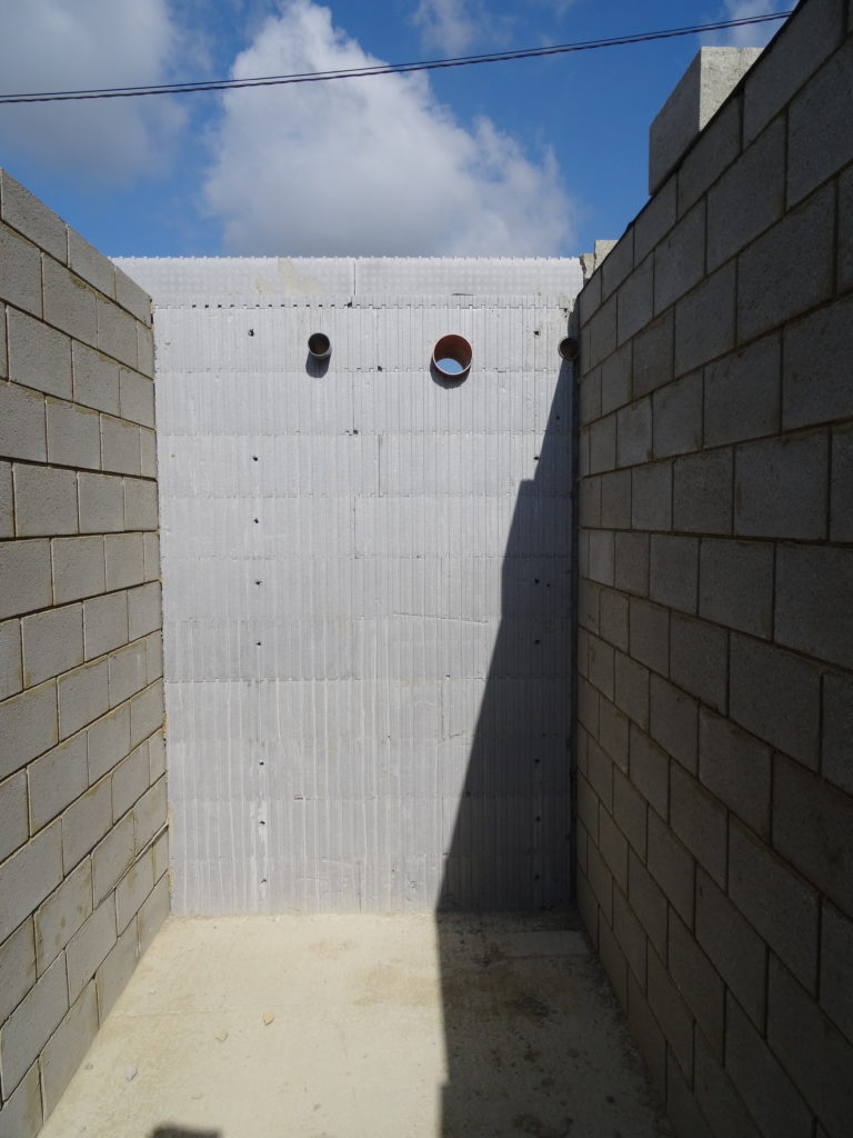 L’isolant a été coupé sur la largeur du bloc de maçonnerie intérieure pour que les deux murs soient bien reliés entre eux.    La liaison entre les deux murs se fait par des crochets fixés tous les deux niveaux.