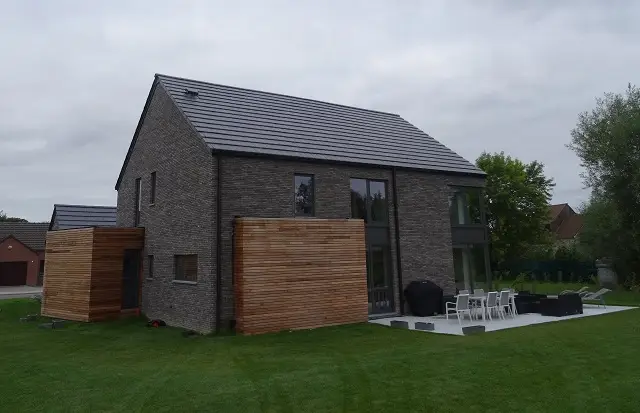 Pour la façade arrière, nous avons posé deux bardages différents et fait une terrasse carrelée blanche... ce qui lui donne un style fort moderne.