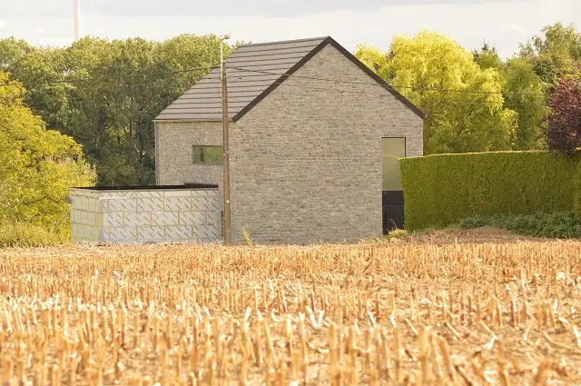 Façade gauche de la maison avec annexe en blocs traditionnels.