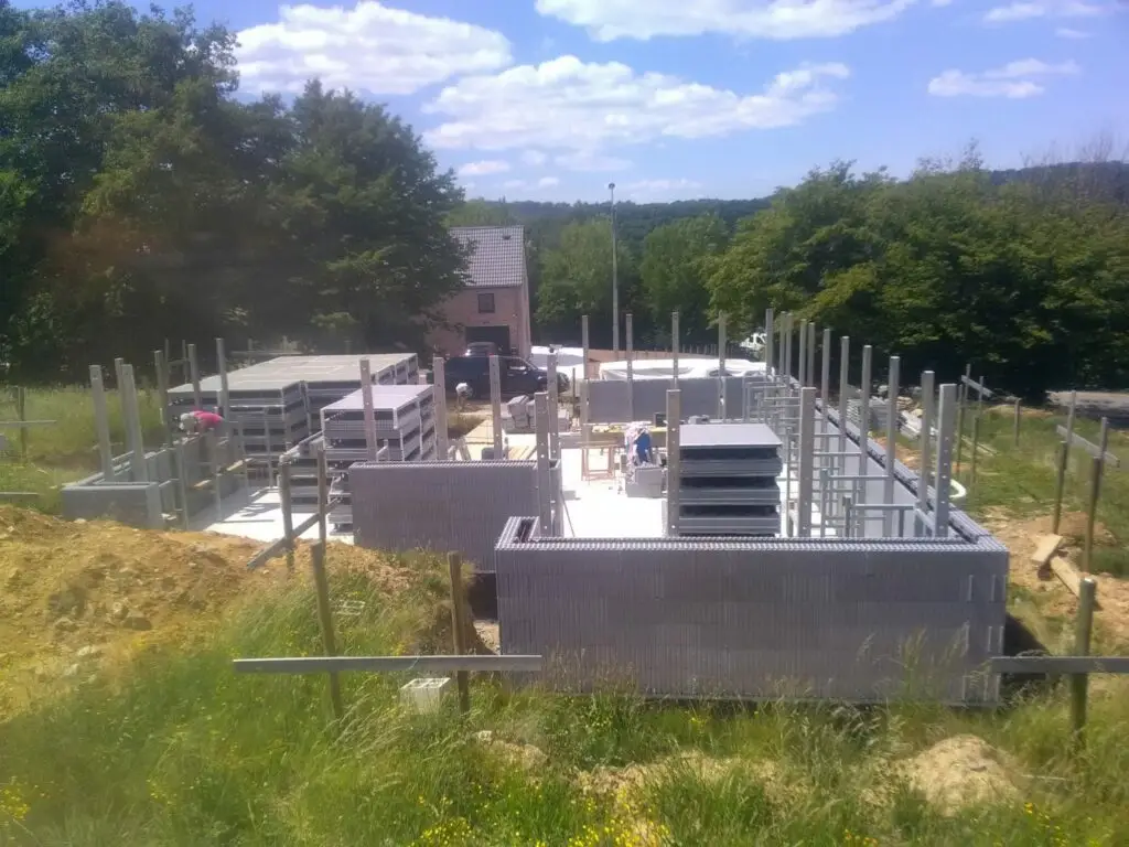 Voilà, notre chantier a bien démarré, premiers niveaux de blocs montés, les étais sont placés, un stock de blocs sur la dalle pour faciliter le travail, on avance vite 😊