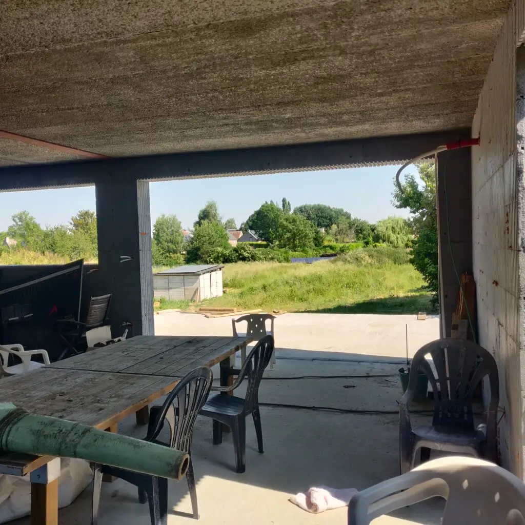 Grande baie vitrée de notre salle à manger. Il y fait déjà si bon que nous y avons déjà installé une table et des chaises.