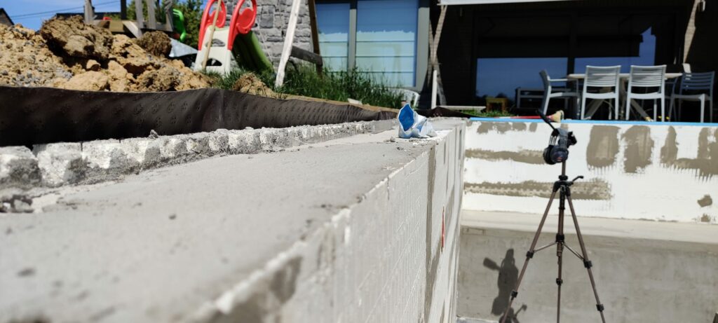 Hier zijn de blokken geplaatst en het beton is gestort. Je ziet duidelijk het gladde oppervlak van de blokken, waardoor je samen met de voering en het liner een perfect glad binnen oppervlak van het zwembad krijgt.