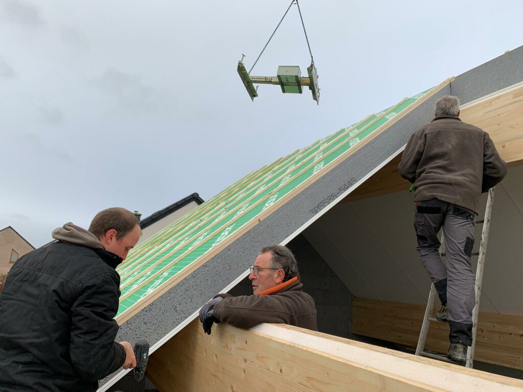 Je ziet hier duidelijk de hydraulische hijshaak die door Isovariant geleverd wordt en die het plaatsen van de panelen heel gemakkelijk en snel maakt.