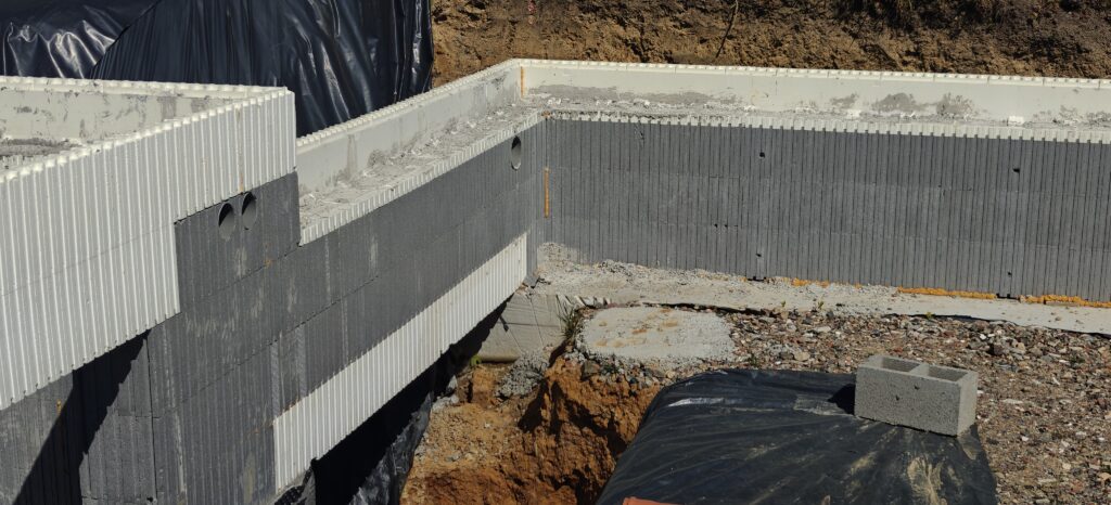 Realisatie van een omgekeerde balk rechtstreeks in het systeem van bekistingsblokken, met integratie van de wapening voor het storten. [in het wit op deze foto]