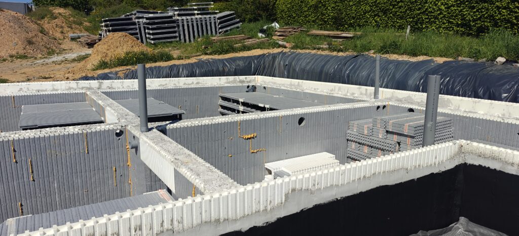 Voor de ondergrondse delen hebben we het systeem aangevuld met een waterafstotende cementering, een bitumineuze coating en een versterkte noppenfolie van het type Platon, voordat we de drainage plaatsten.