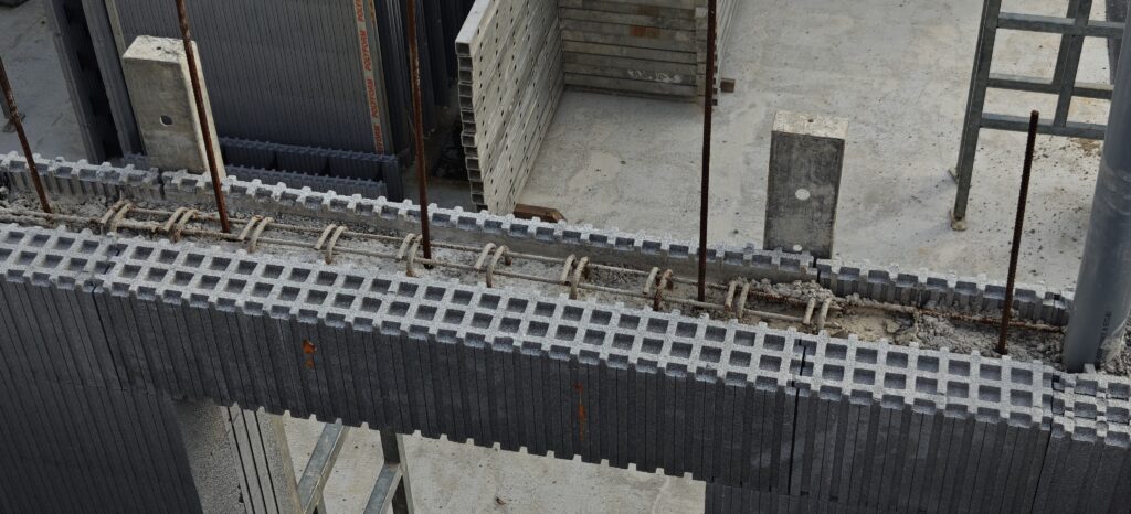Detail van de latei, de stalen wapening die de raamopening ondersteunt, rechtstreeks geïntegreerd in het blok voor het storten.