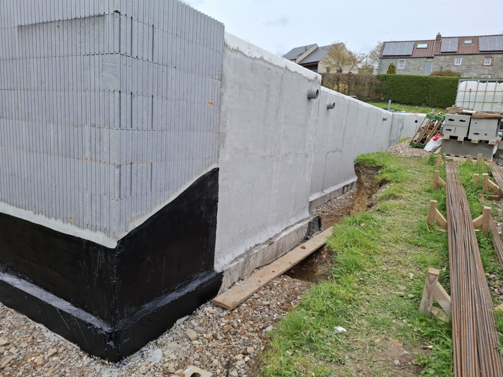 Waterafstotende cementering op alle ondergrondse delen, gevolgd door twee lagen bitumineuze coating (reeds begonnen aan de linkerkant van de foto).